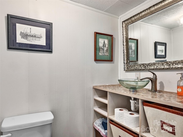 bathroom featuring crown molding, sink, and toilet