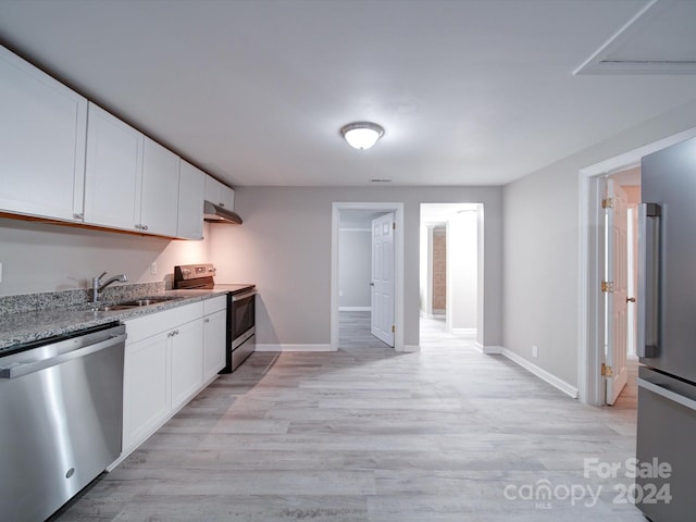 kitchen featuring white cabinetry, sink, light hardwood / wood-style floors, and appliances with stainless steel finishes