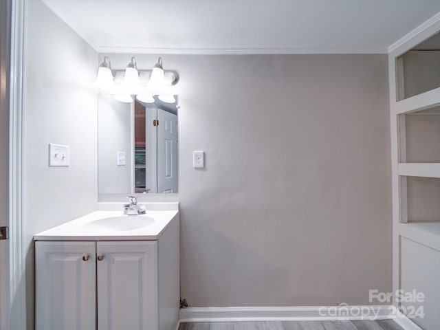 bathroom with vanity, wood-type flooring, and ornamental molding