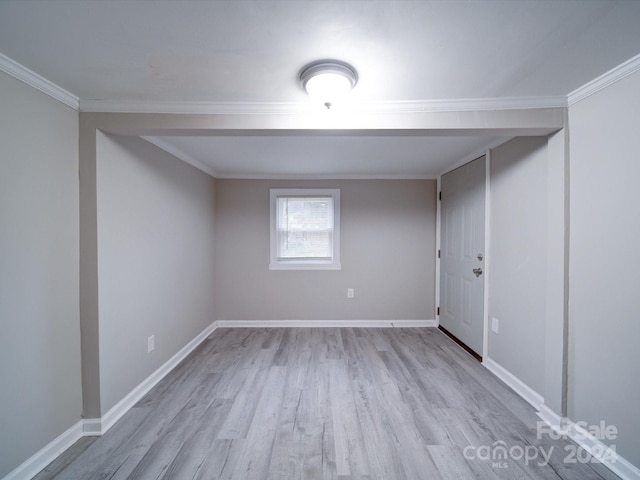 empty room with crown molding and light hardwood / wood-style flooring