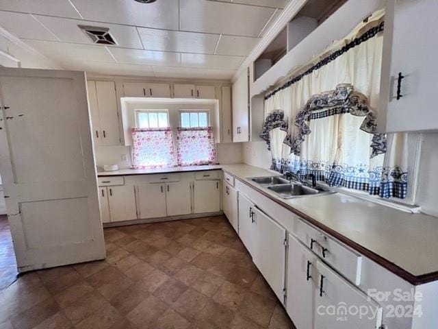 kitchen featuring white cabinetry and sink