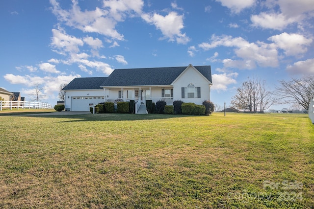 view of front of property featuring a front yard, a porch, and a garage