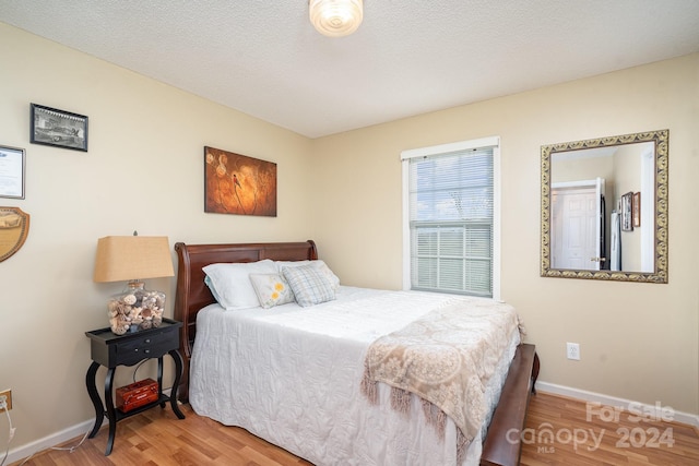 bedroom featuring hardwood / wood-style flooring and a textured ceiling