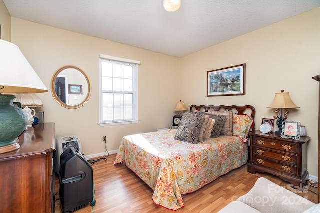 bedroom featuring a textured ceiling and light hardwood / wood-style floors