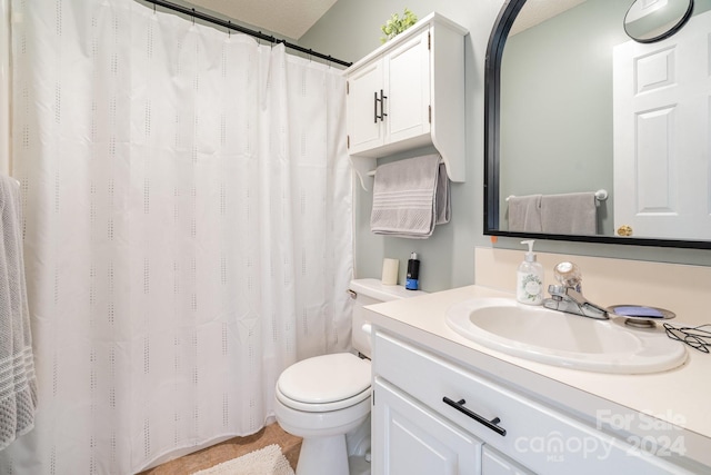 bathroom featuring vanity, toilet, and a textured ceiling