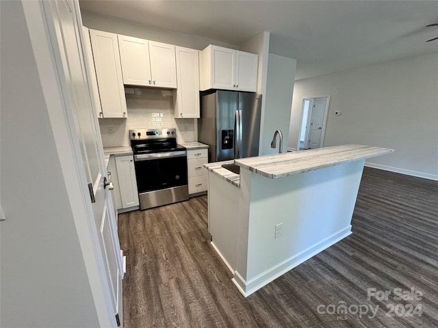 kitchen featuring a center island, dark wood-type flooring, tasteful backsplash, white cabinetry, and stainless steel appliances