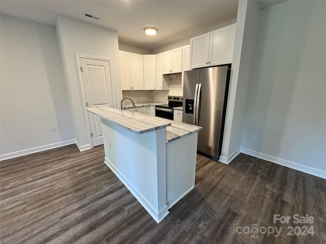 kitchen with white cabinetry, dark wood-type flooring, stainless steel appliances, light stone counters, and a kitchen island with sink