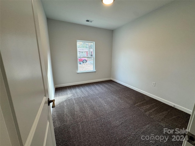 empty room featuring dark carpet