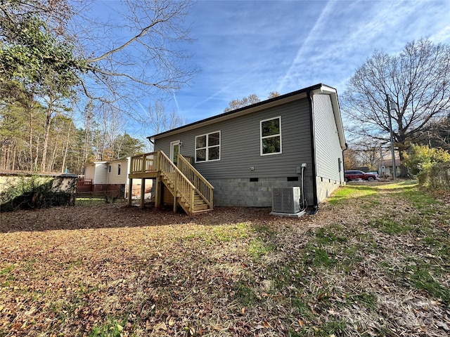 back of house with a deck and central air condition unit