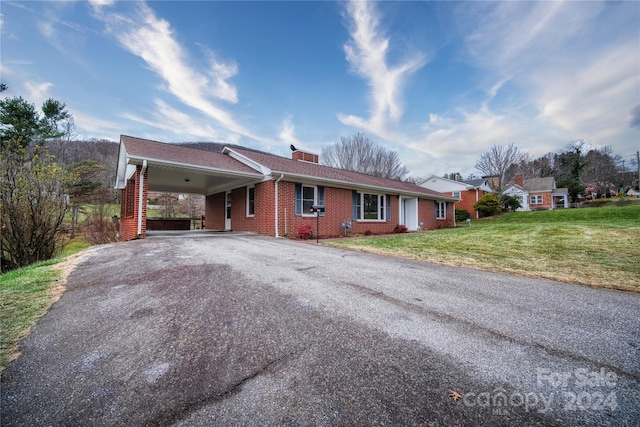 ranch-style home with a front yard and a carport