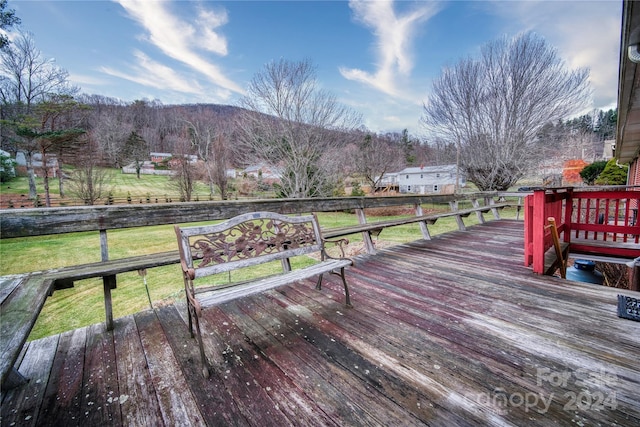 deck with a mountain view and a yard