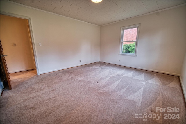 unfurnished room with carpet and crown molding