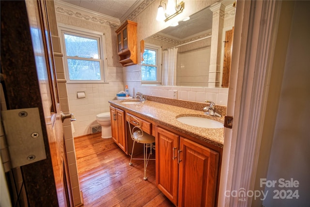 bathroom featuring hardwood / wood-style floors, vanity, crown molding, toilet, and tile walls