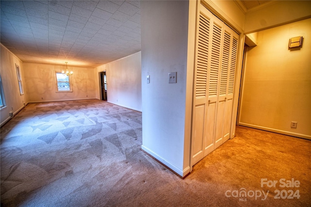 hallway with carpet flooring and an inviting chandelier