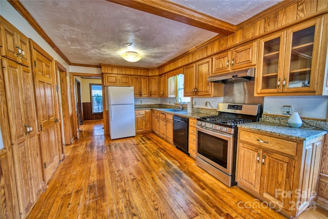 kitchen featuring black dishwasher, stainless steel gas stove, white refrigerator, and a wealth of natural light