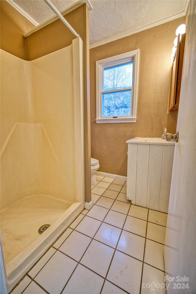 bathroom with a shower, tile patterned floors, crown molding, and toilet