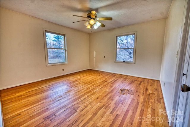 empty room featuring ceiling fan, a textured ceiling, and light wood-type flooring