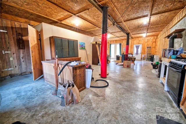 basement with a wood stove and wooden walls