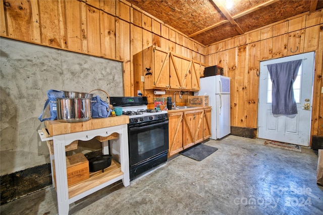 kitchen featuring gas stove, white refrigerator, and sink