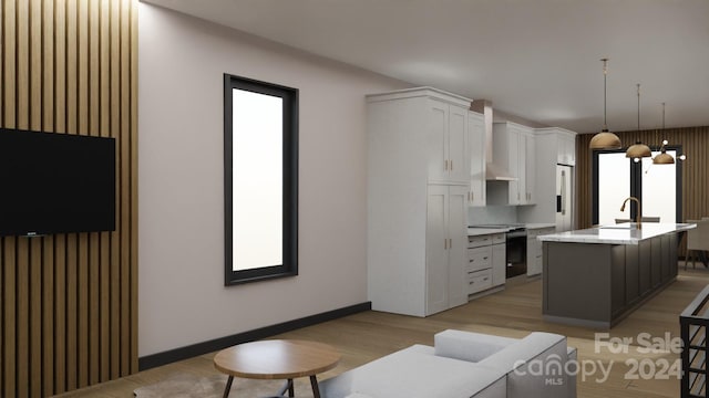 kitchen featuring white cabinetry, electric range, light hardwood / wood-style floors, decorative light fixtures, and a kitchen island with sink