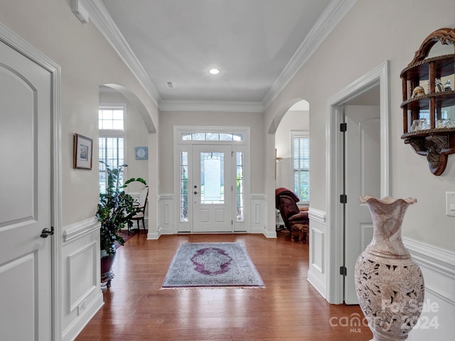 entrance foyer with wood-type flooring, plenty of natural light, and crown molding