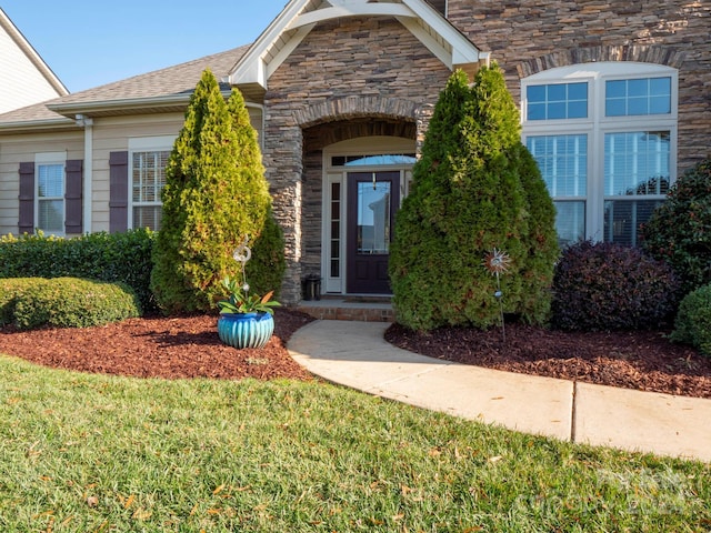 property entrance with a lawn