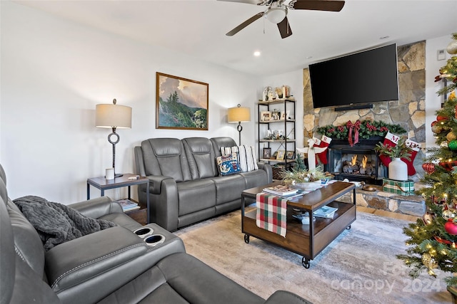 living room featuring ceiling fan and a fireplace