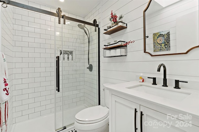 bathroom with vanity, wood walls, toilet, and walk in shower