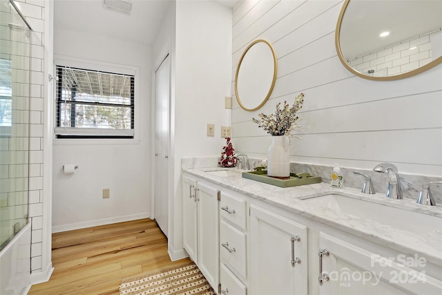 bathroom with bathing tub / shower combination, vanity, and wood-type flooring