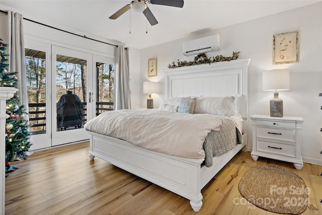 bedroom with ceiling fan, a wall unit AC, access to outside, and light hardwood / wood-style flooring