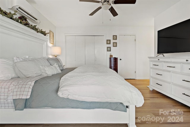 bedroom with a wall unit AC, ceiling fan, and light wood-type flooring