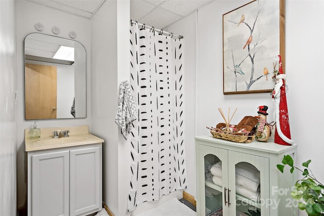 bathroom featuring a shower with curtain, a drop ceiling, and vanity