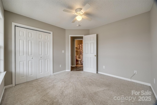 unfurnished bedroom with ceiling fan, a closet, carpet floors, and a textured ceiling