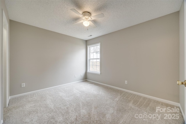 carpeted spare room featuring ceiling fan and a textured ceiling