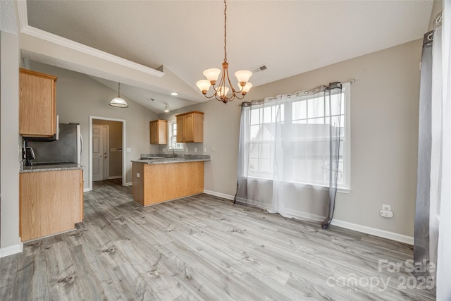 kitchen with kitchen peninsula, light hardwood / wood-style flooring, hanging light fixtures, and lofted ceiling