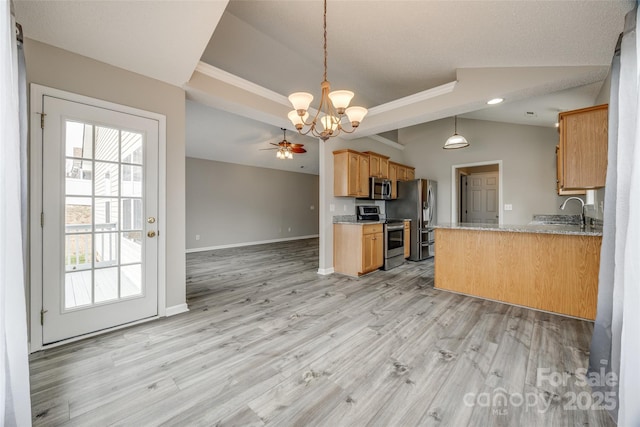 kitchen featuring kitchen peninsula, appliances with stainless steel finishes, light hardwood / wood-style flooring, and pendant lighting