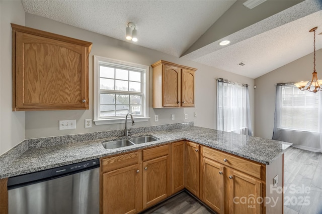 kitchen featuring kitchen peninsula, stainless steel dishwasher, lofted ceiling, and sink