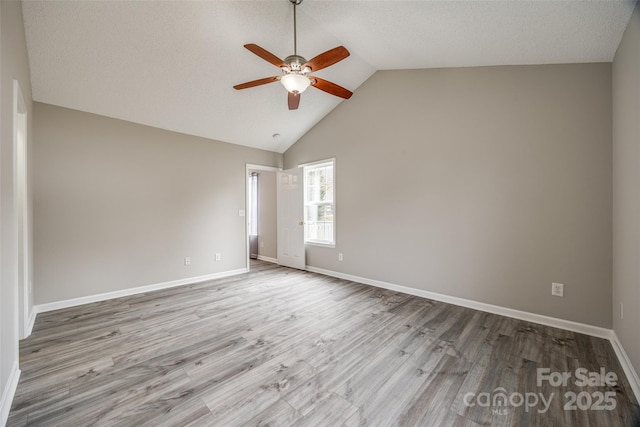 unfurnished room with ceiling fan, light hardwood / wood-style floors, and lofted ceiling