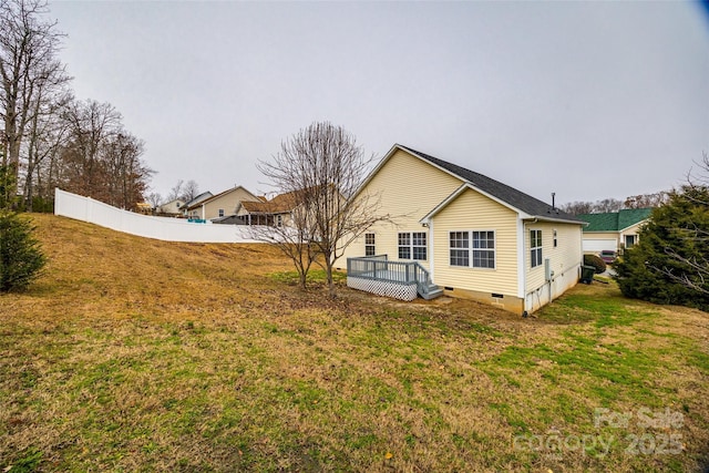 back of house featuring a wooden deck and a yard