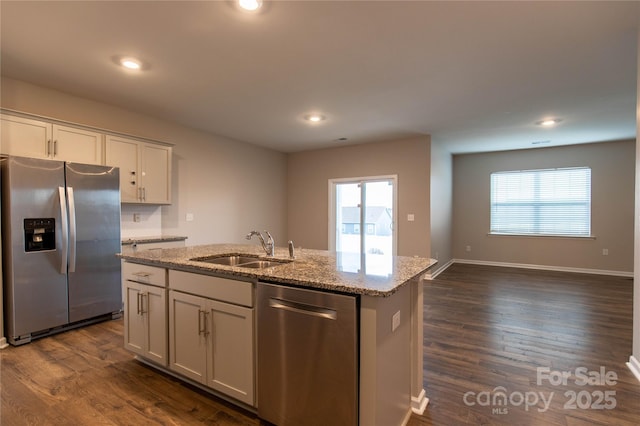 kitchen featuring sink, light stone counters, appliances with stainless steel finishes, a kitchen island with sink, and white cabinets