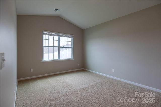 empty room with vaulted ceiling and light carpet