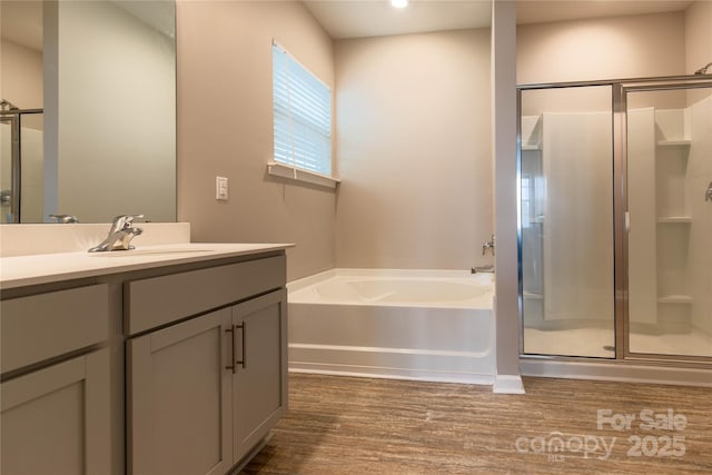 bathroom with vanity, hardwood / wood-style floors, and separate shower and tub