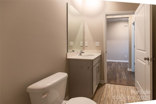 bathroom featuring wood-type flooring, vanity, and toilet