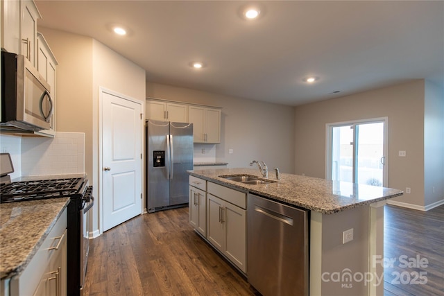 kitchen featuring a kitchen island with sink, a sink, dark wood finished floors, recessed lighting, and appliances with stainless steel finishes