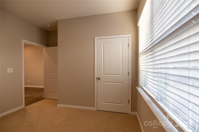 unfurnished bedroom with baseboards and light colored carpet