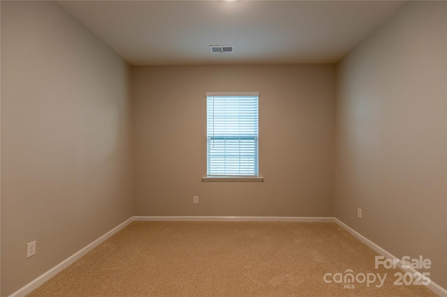 unfurnished room with light colored carpet, visible vents, and baseboards