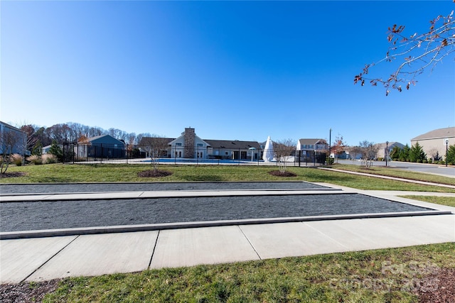 view of property's community featuring a yard, a residential view, and fence