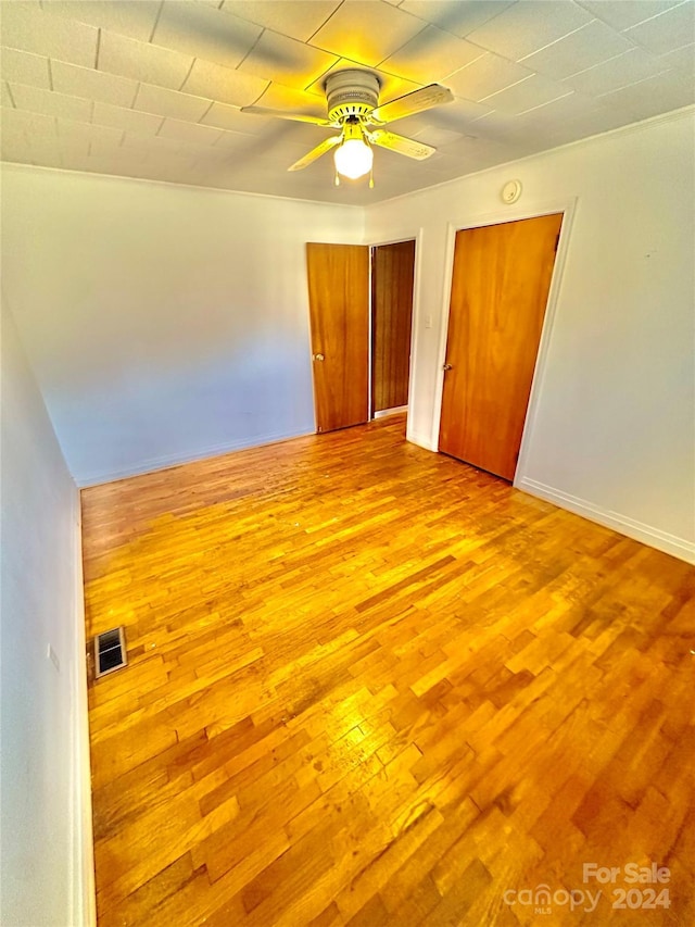 unfurnished bedroom with ceiling fan and light hardwood / wood-style flooring