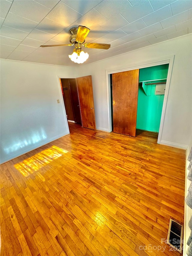 unfurnished bedroom with light wood-type flooring, a closet, and ceiling fan