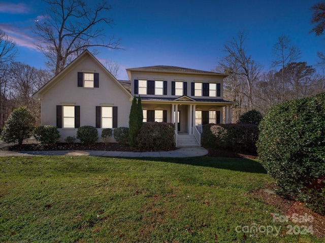 view of property featuring a lawn and covered porch